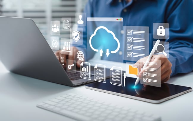 représente une personne travaillant sur ordinateur portable et tablette, téléchargeant des données du cloud