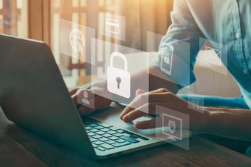 Représente une personne devant son ordinateur portable en processus d'authentification MFA