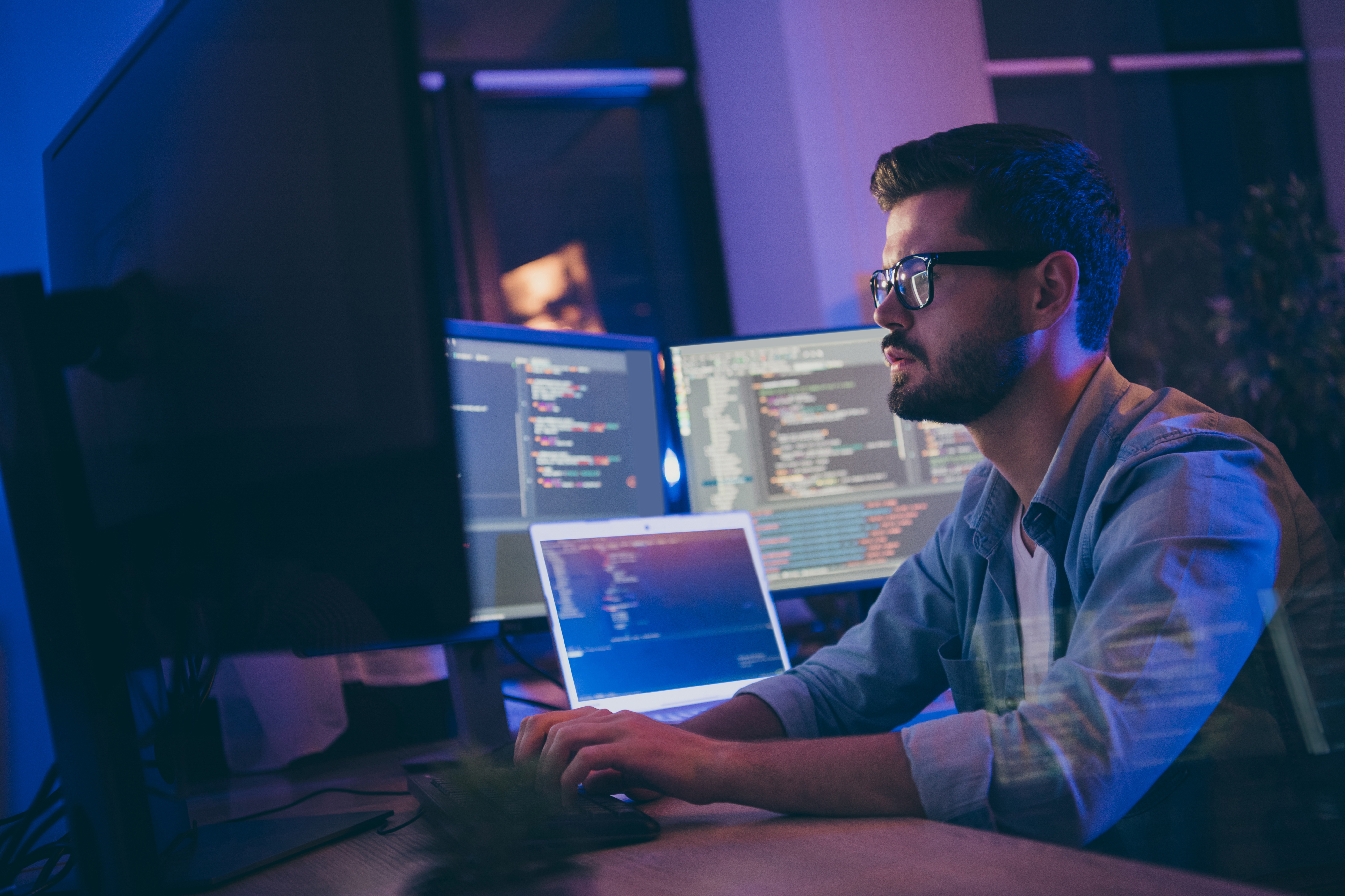 un programmeur face à plusieurs écrans