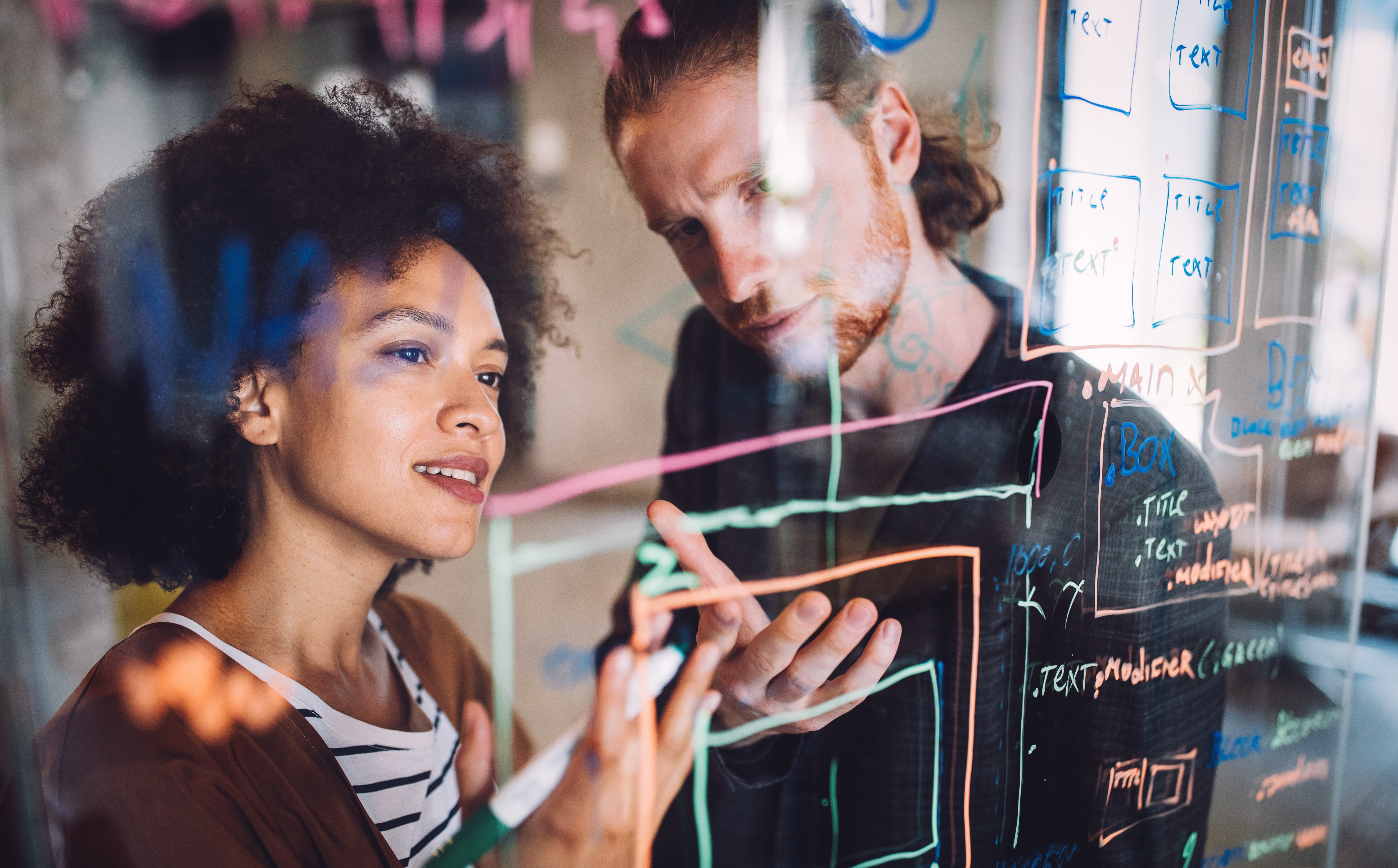 un homme et une femme collaborant autour d'un graphique