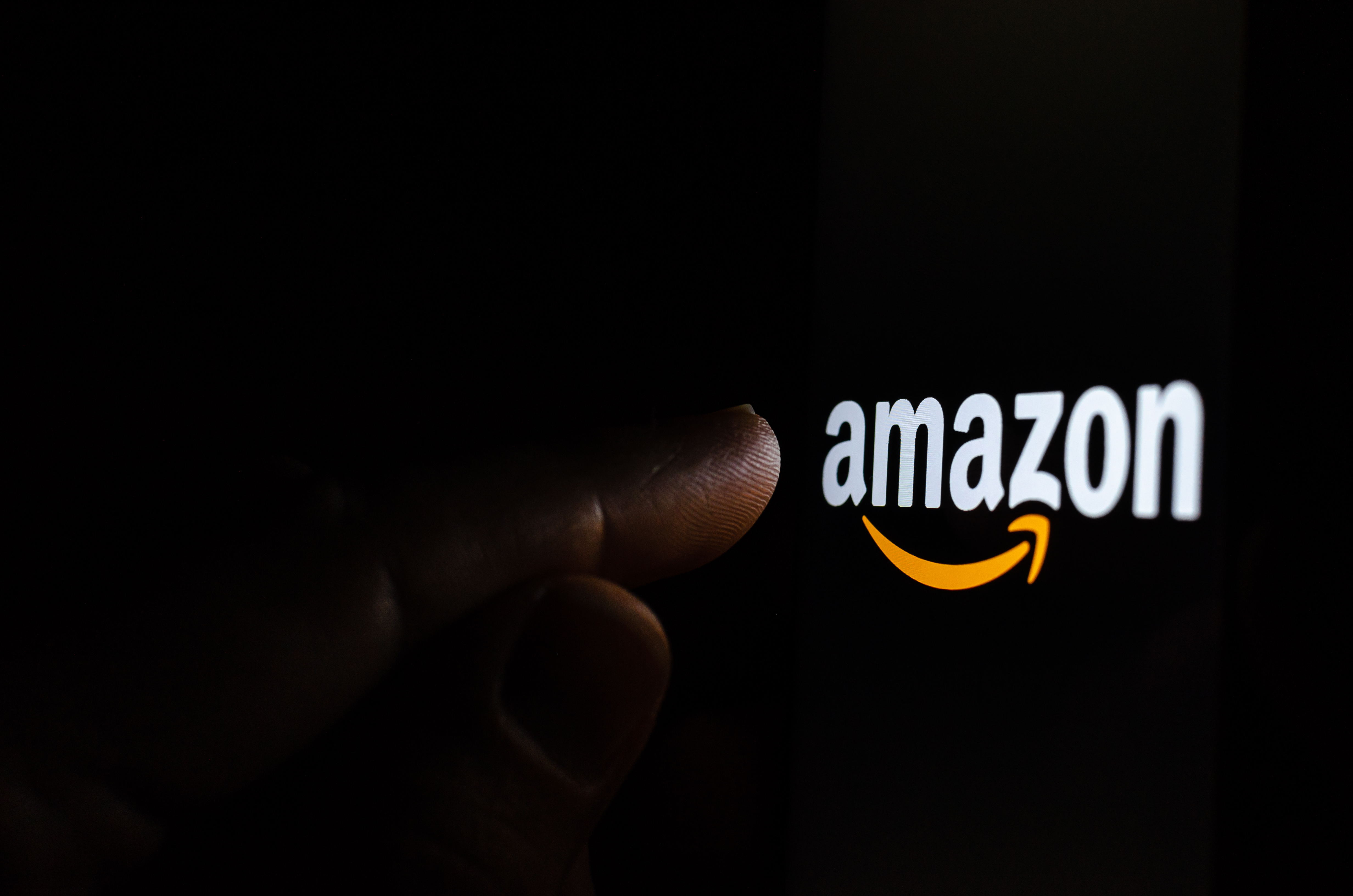 photo d'un doigt pointant le logo Amazon